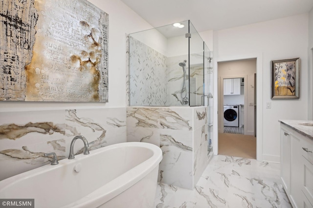 13708 Park Haven Trl, Prior Lake, MN 55372 - bathroom featuring a marble finish shower, a freestanding bath, marble finish floors, vanity, and washing machine and dryer