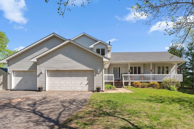traditional-style home with a porch, an attached garage, driveway, a front yard, and roof with shingles