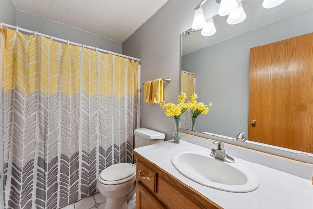 full bathroom featuring toilet, vanity, and a textured ceiling