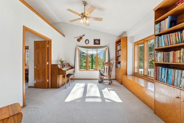 living area with carpet flooring, vaulted ceiling, a ceiling fan, and baseboards
