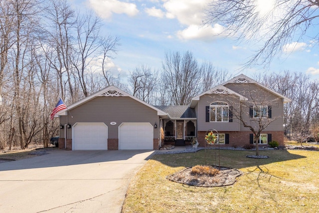 split level home featuring brick siding, an attached garage, concrete driveway, and a front yard