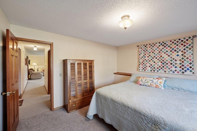 bedroom featuring light carpet and a textured ceiling