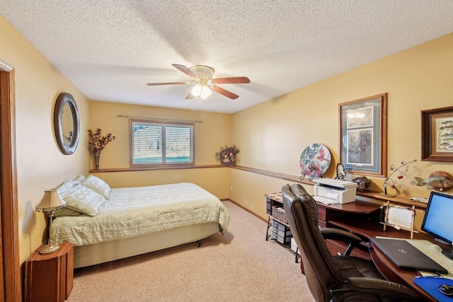 carpeted bedroom featuring an office area, a textured ceiling, and ceiling fan