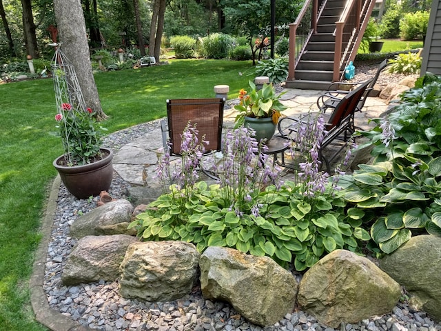 view of grassy yard with stairs and a patio area