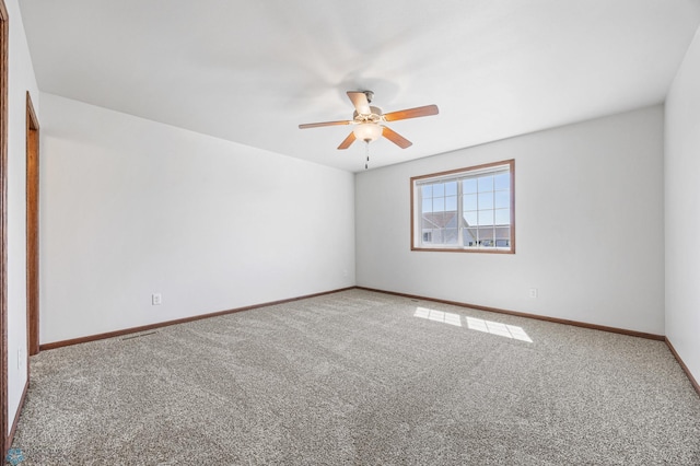 carpeted empty room featuring a ceiling fan and baseboards