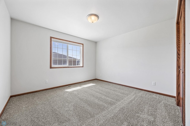 empty room featuring carpet flooring and baseboards