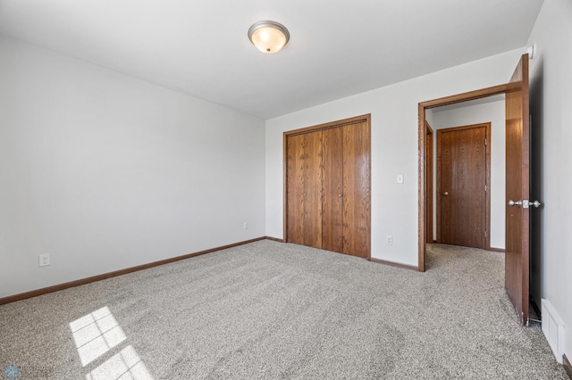 unfurnished bedroom featuring carpet flooring, a closet, and baseboards