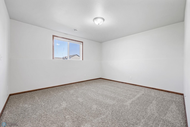 carpeted spare room featuring baseboards