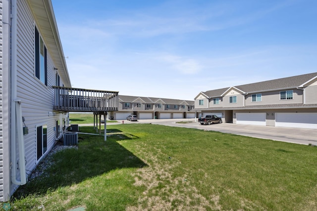 view of green lawn featuring a residential view, cooling unit, and a wooden deck