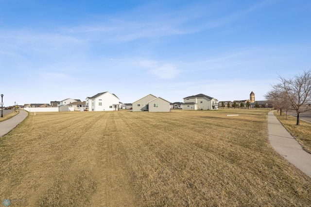 view of green lawn with a residential view