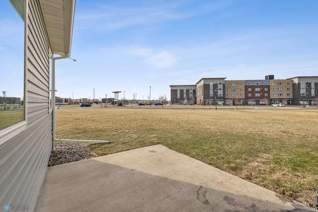 view of green lawn featuring a patio area