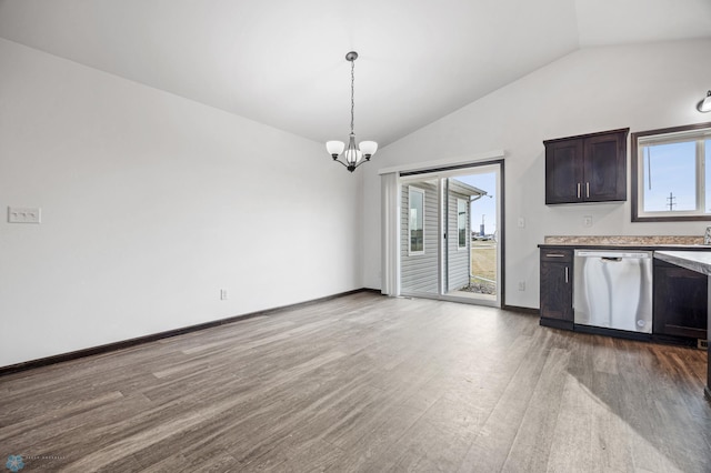 kitchen with dishwasher, vaulted ceiling, light wood finished floors, light countertops, and a chandelier
