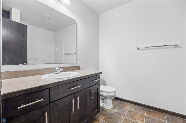bathroom featuring toilet, vanity, and baseboards