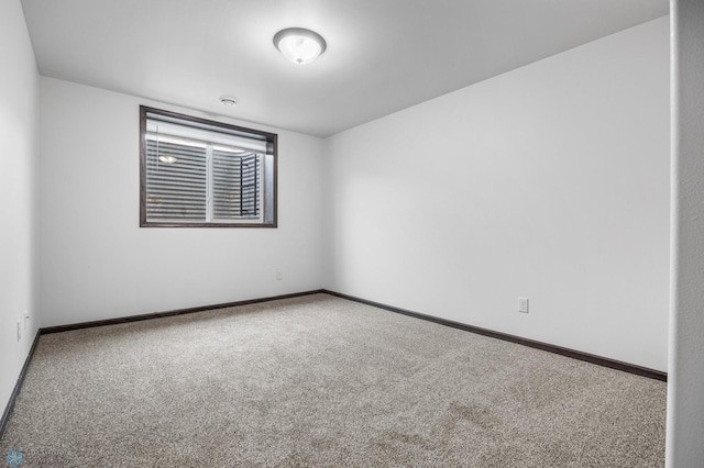 carpeted empty room featuring baseboards