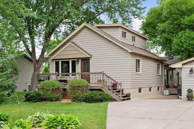 bungalow featuring a front yard, a wooden deck, and a shingled roof