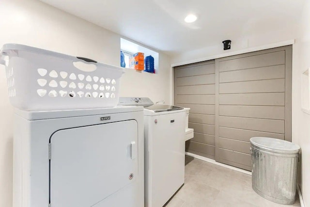 clothes washing area featuring washer and dryer and light tile patterned flooring