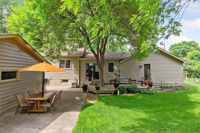 rear view of house featuring a lawn, a wooden deck, a patio area, and outdoor dining space