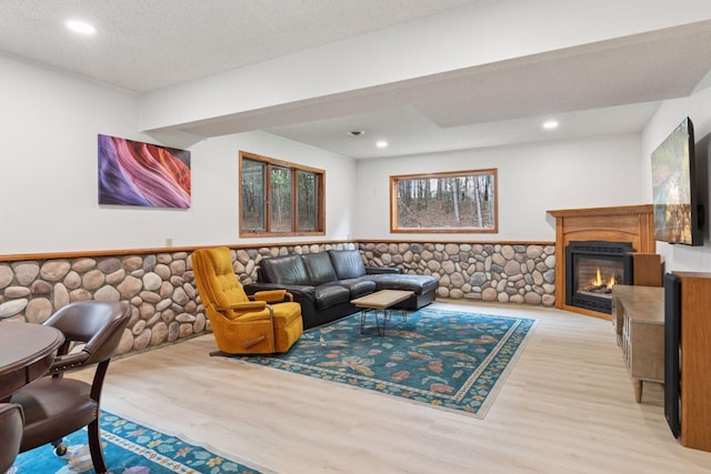265 Red Pine Trl, Saint Joseph Twp, WI 54016 - living area featuring light wood-style flooring, recessed lighting, a glass covered fireplace, and wainscoting