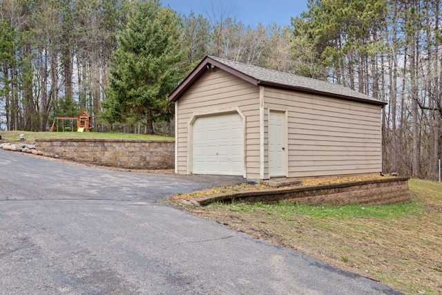 265 Red Pine Trl, Saint Joseph Twp, WI 54016 - detached garage featuring asphalt driveway and view of scattered trees