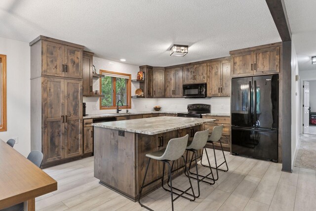 265 Red Pine Trl, Saint Joseph Twp, WI 54016 - kitchen featuring black appliances, a sink, open shelves, a kitchen island, and light wood-style floors