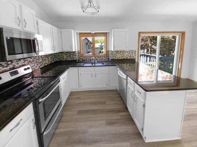 4984 Park Dr, Savage, MN 55378 - kitchen with appliances with stainless steel finishes, a peninsula, plenty of natural light, and white cabinets