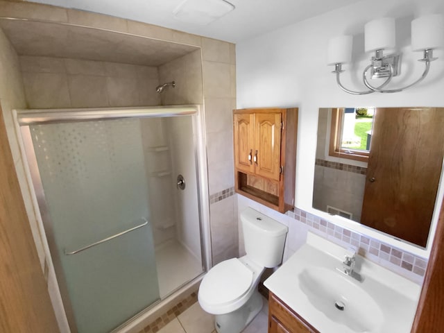 4984 Park Dr, Savage, MN 55378 - bathroom featuring tile walls, a stall shower, vanity, toilet, and tile patterned flooring