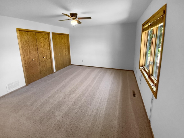 4984 Park Dr, Savage, MN 55378 - unfurnished bedroom with multiple closets, carpet floors, baseboards, and a ceiling fan