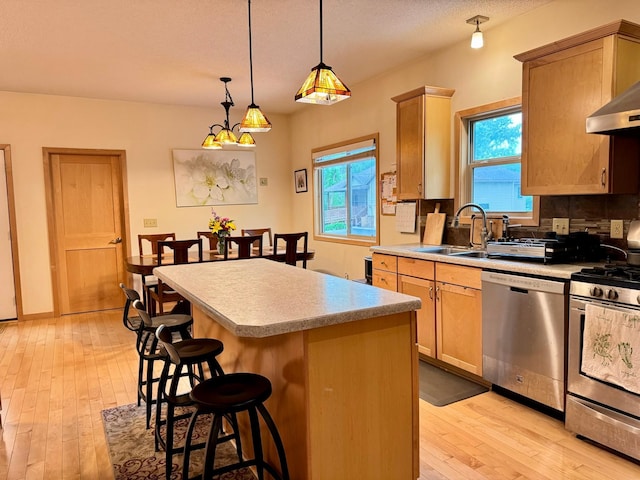 766 County Road F E, Vadnais Heights, MN 55127 - kitchen featuring appliances with stainless steel finishes, a sink, light wood-style flooring, a breakfast bar, and a center island