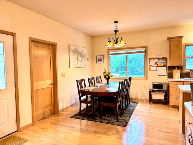 766 County Road F E, Vadnais Heights, MN 55127 - dining room with light wood finished floors, a chandelier, and baseboards