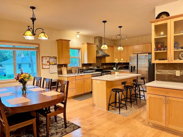 766 County Road F E, Vadnais Heights, MN 55127 - kitchen with wall chimney exhaust hood, stainless steel appliances, tasteful backsplash, light countertops, and a center island