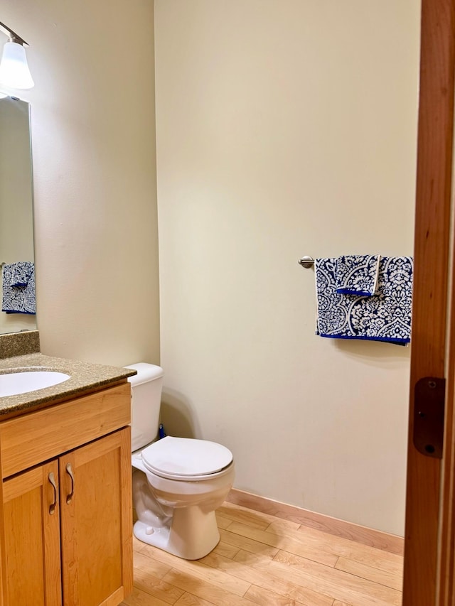766 County Road F E, Vadnais Heights, MN 55127 - half bath featuring wood finished floors, toilet, vanity, and baseboards