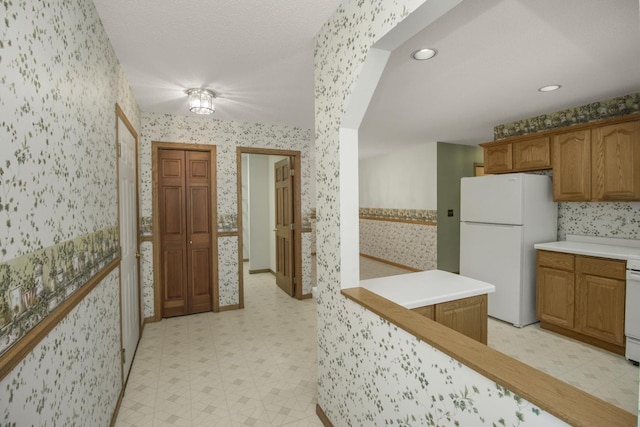 1922 Eastridge Ct, Stillwater, MN 55082 - kitchen with wallpapered walls, freestanding refrigerator, light floors, light countertops, and brown cabinetry