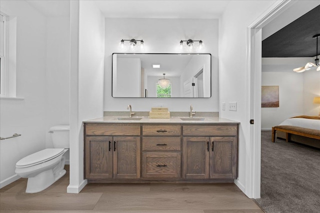 3822 Northern Ave, Spring Park, MN 55384 - bathroom with connected bathroom, toilet, baseboards, double vanity, and wood finished floors