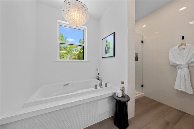 3822 Northern Ave, Spring Park, MN 55384 - full bathroom with a chandelier, a shower stall, a bath, and wood finished floors