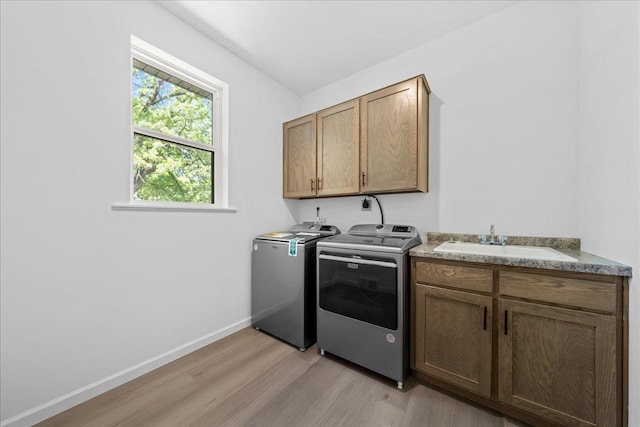 3822 Northern Ave, Spring Park, MN 55384 - laundry room with washer and clothes dryer, light wood-type flooring, cabinet space, and baseboards