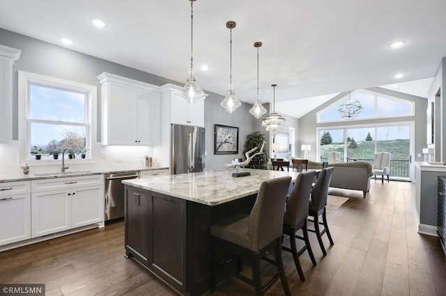 13714 Park Haven Trl NE, Prior Lake, MN 55372 - kitchen with appliances with stainless steel finishes, a sink, a chandelier, light stone counters, and a center island