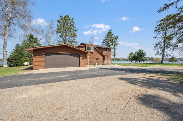 19490 Ruff Shores Rd, Harris Twp, MN 55744 - chalet / cabin featuring a garage, a water view, and driveway