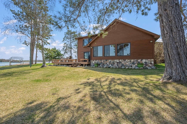 19490 Ruff Shores Rd, Harris Twp, MN 55744 - rear view of house with a deck with water view, a yard, and stone siding