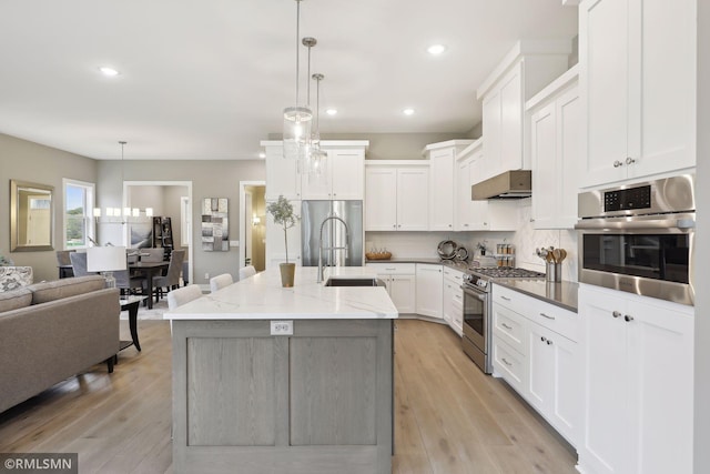 4104 Osprey Ct, Prior Lake, MN 55372 - kitchen with stainless steel appliances, a sink, recessed lighting, under cabinet range hood, and decorative backsplash