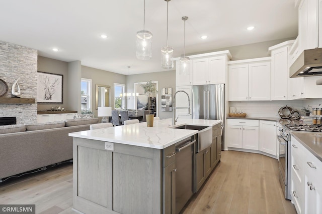 4104 Osprey Ct, Prior Lake, MN 55372 - kitchen with stainless steel appliances, a sink, white cabinetry, light wood-type flooring, and a kitchen island with sink