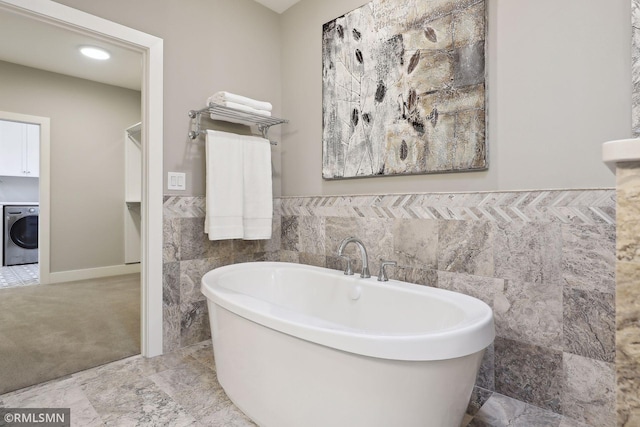 4104 Osprey Ct, Prior Lake, MN 55372 - full bath with washer / dryer, tile walls, a soaking tub, and wainscoting