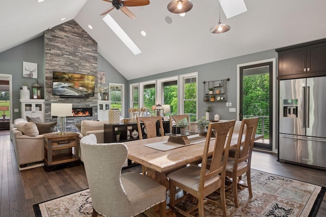 1701 Retreat Cir, Minnetrista, MN 55364 - dining space featuring a skylight, high vaulted ceiling, dark wood finished floors, a stone fireplace, and a ceiling fan