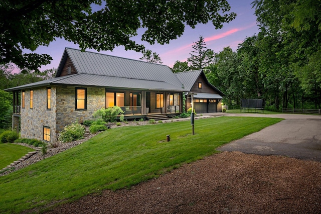 1701 Retreat Cir, Minnetrista, MN 55364 - view of front facade with stone siding, a porch, a garage, concrete driveway, and a metal roof