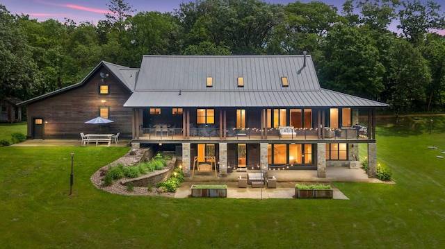 1701 Retreat Cir, Minnetrista, MN 55364 - rear view of property with a patio area, a yard, stone siding, a standing seam roof, and a balcony