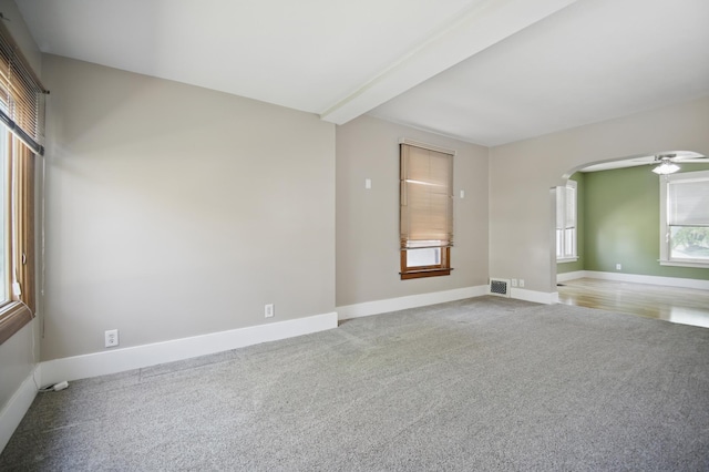 733 1st St SW, Faribault, MN 55021 - carpeted empty room with baseboards, arched walkways, a ceiling fan, and beamed ceiling