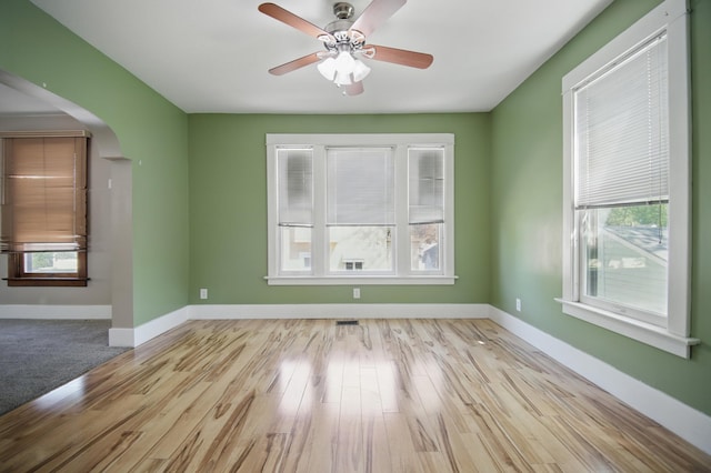733 1st St SW, Faribault, MN 55021 - empty room featuring arched walkways, wood finished floors, baseboards, and ceiling fan