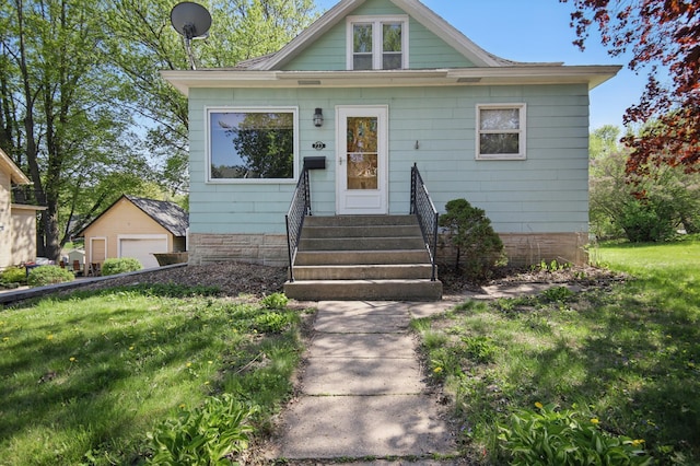 733 1st St SW, Faribault, MN 55021 - bungalow featuring a garage, a front lawn, and entry steps