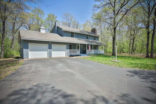 127 County Rd W, Pleasant Valley Twp, WI 54022 - farmhouse featuring a porch, a chimney, driveway, a garage, and a front lawn