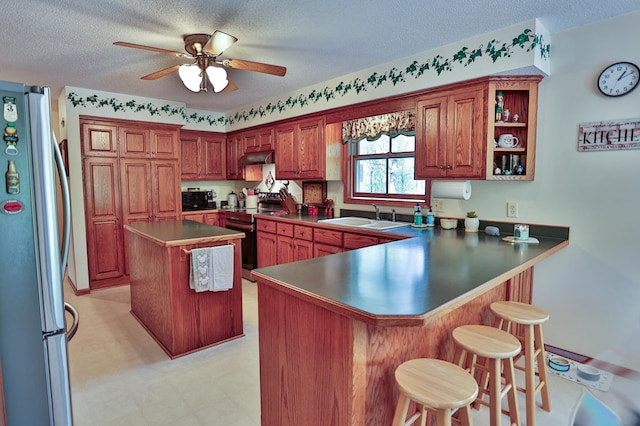 127 County Rd W, Pleasant Valley Twp, WI 54022 - kitchen featuring appliances with stainless steel finishes, a sink, a peninsula, ceiling fan, and a breakfast bar area