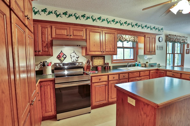 127 County Rd W, Pleasant Valley Twp, WI 54022 - kitchen with stainless steel range with electric stovetop, under cabinet range hood, brown cabinets, a textured ceiling, and a sink